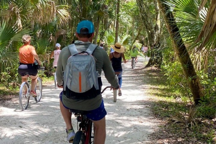 a man riding a bike down a dirt road