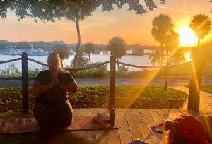 a person sitting at a table in front of a sunset