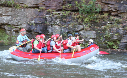 a group of people riding on the back of a boat in the water