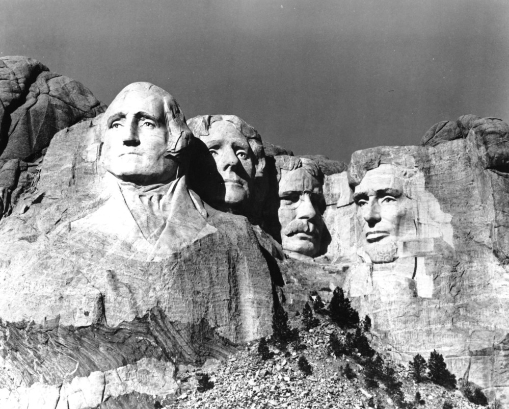 an old photo of Lincoln Borglum with Mount Rushmore National Memorial in the background