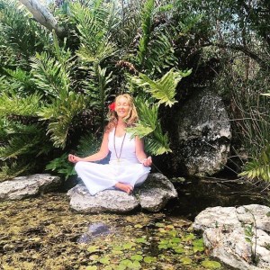 a girl sitting on a rock next to a tree