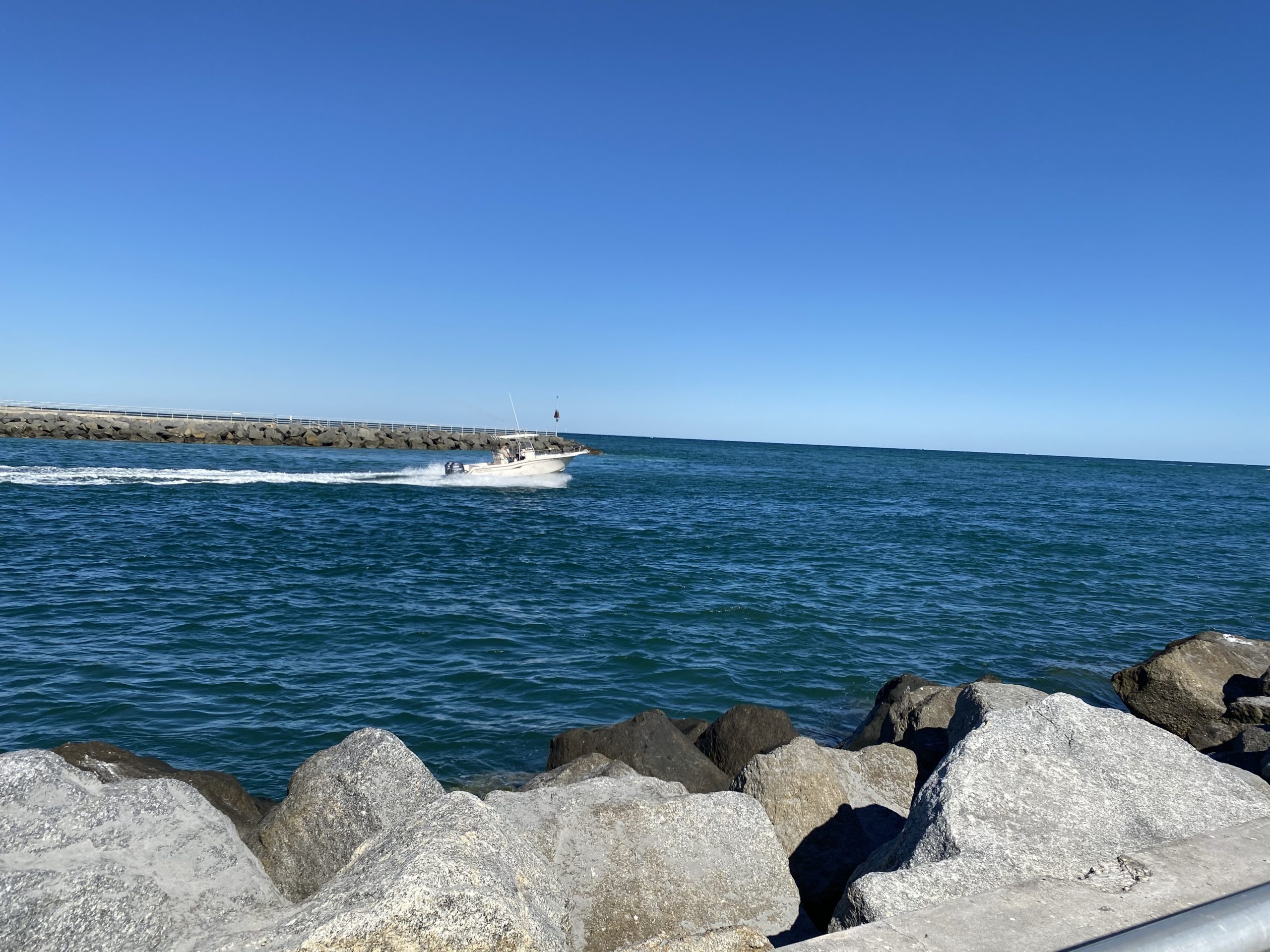 a person sitting on a rock near the ocean