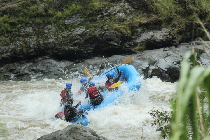 a man riding a wave on a raft in a body of water