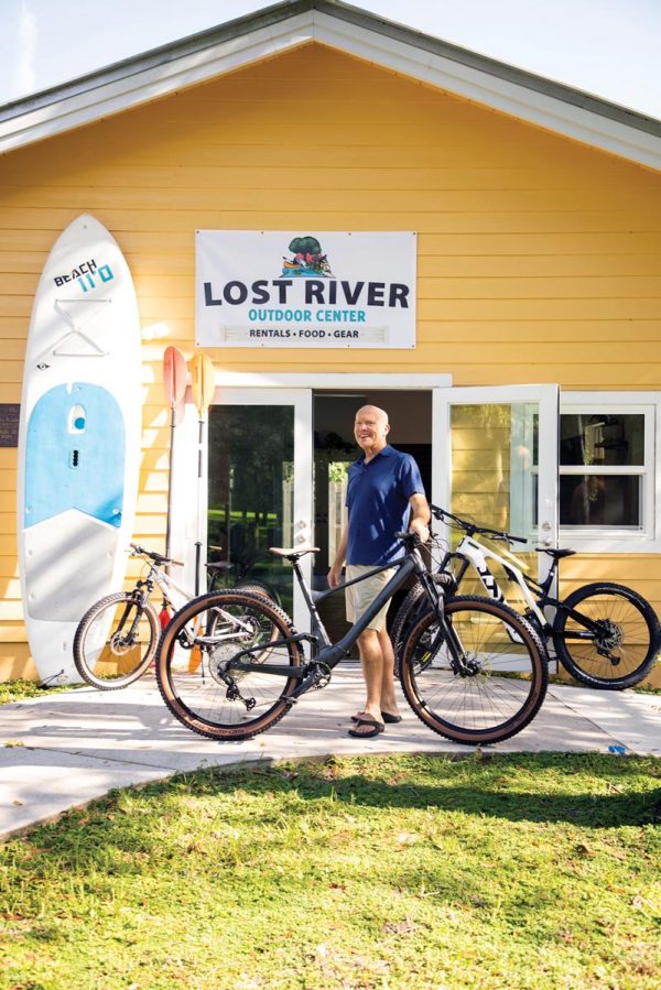 a man with a bicycle in front of a house