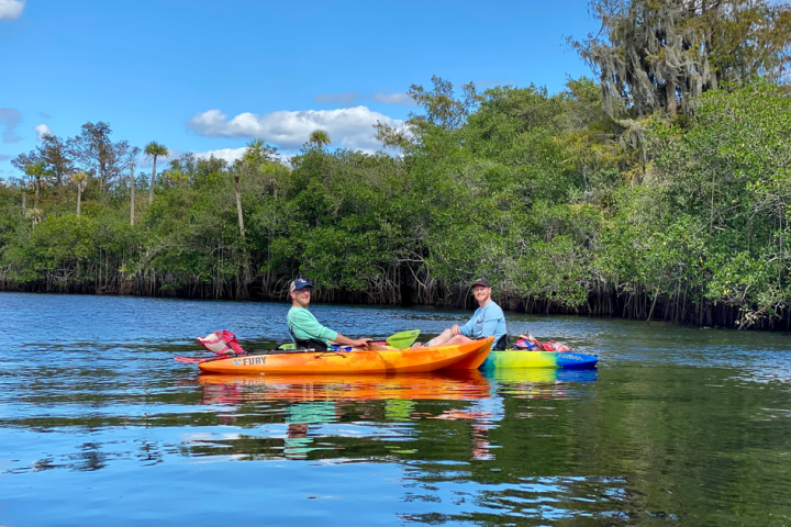a group of people rowing a boat in the water