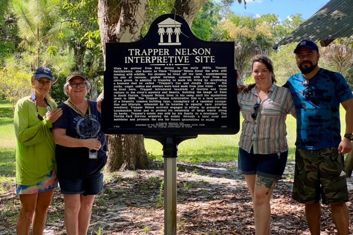 a group of people standing next to a tree