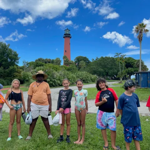 a group of people standing on top of a grass covered field