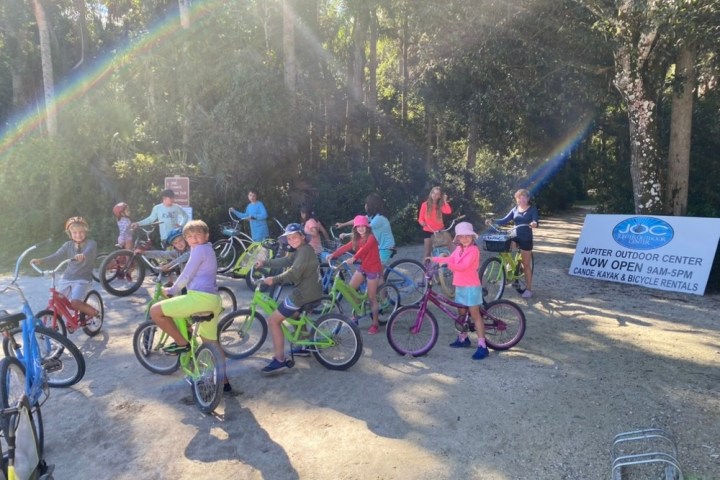 a group of people riding on the back of a bicycle
