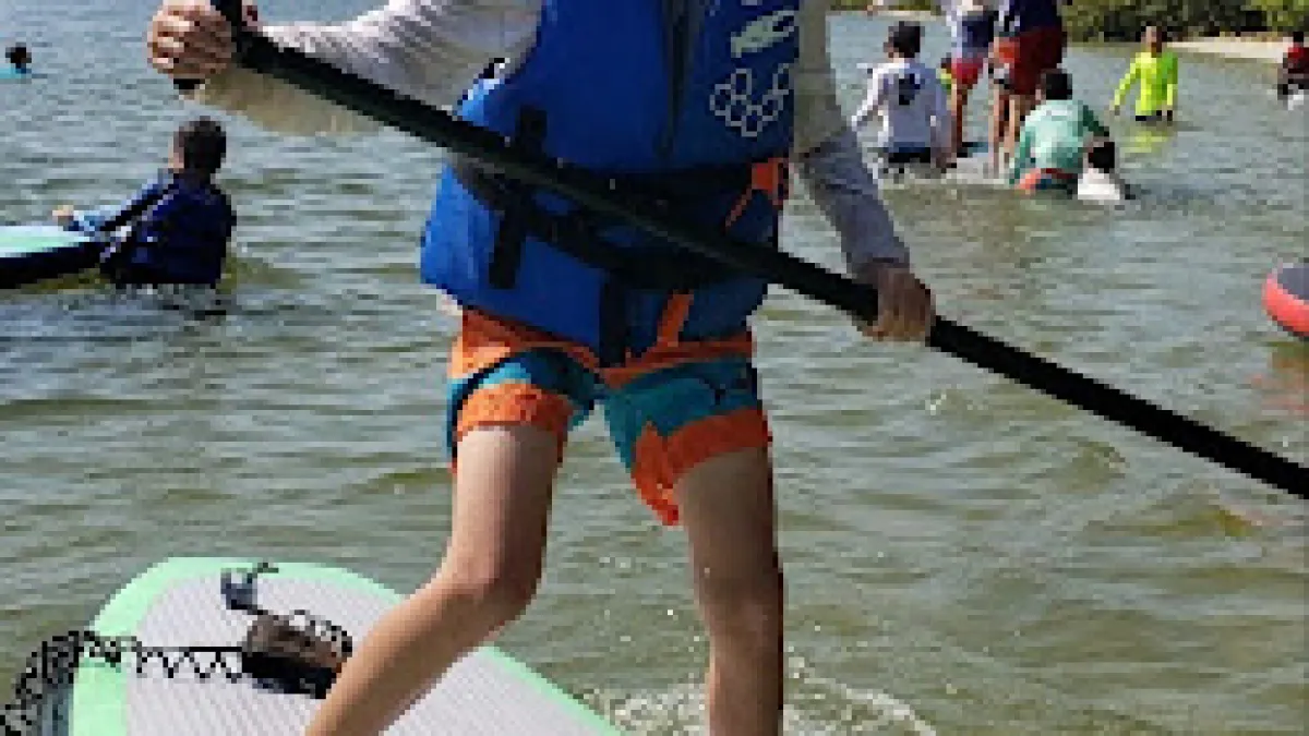 a group of people riding on the back of a boat in the water